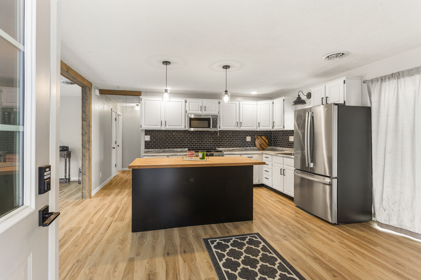 402 South Washington Street Saybrook, IL 61770 - Photo 8 of 24 a large kitchen with stainless steel appliances granite countertop a refrigerator a sink dishwasher a stove and white cabinets with wooden floor