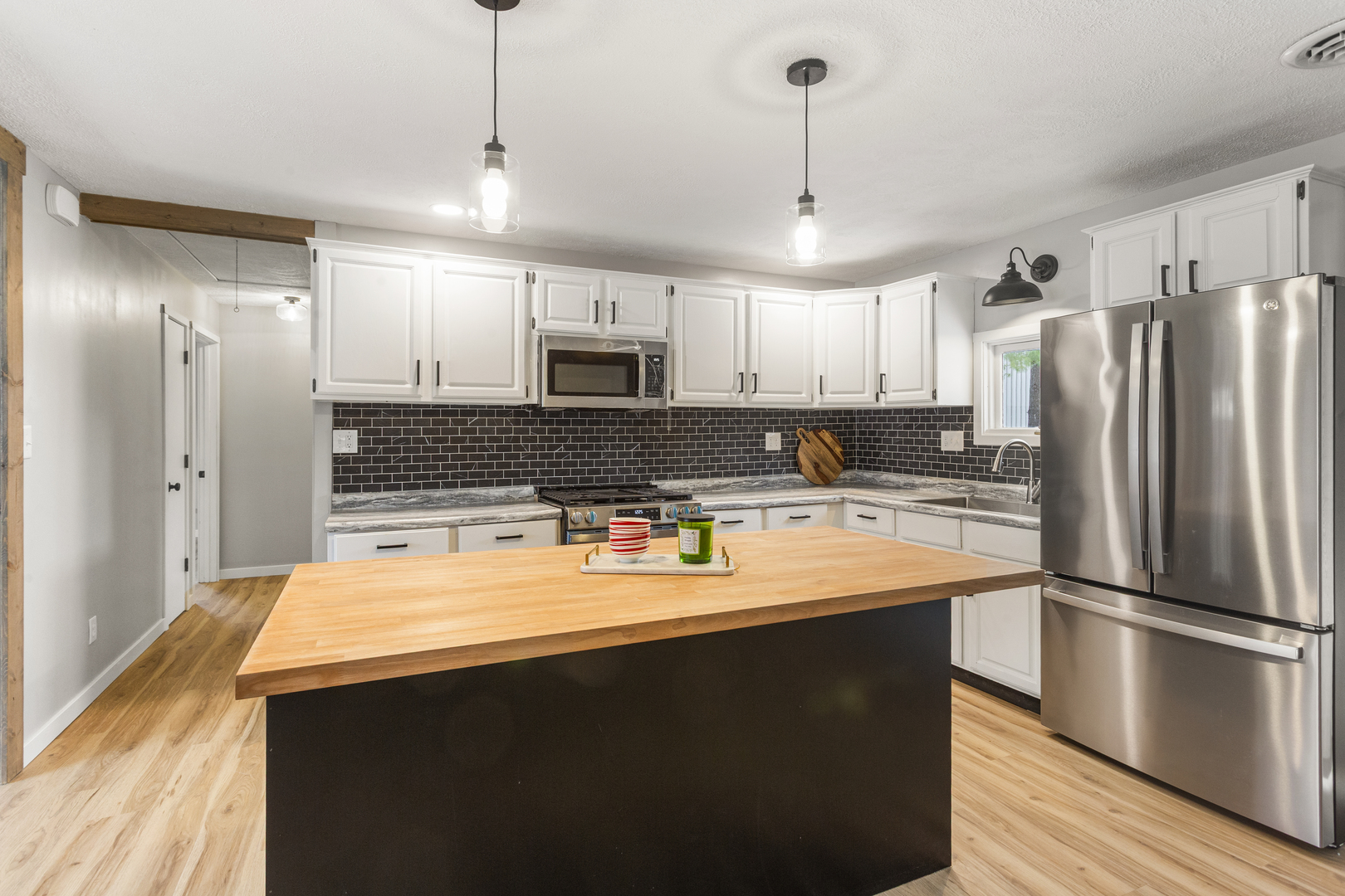 402 South Washington Street Saybrook, IL 61770 - Photo 9 of 24 a large kitchen with stainless steel appliances a refrigerator a sink a stove a microwave and wooden floor