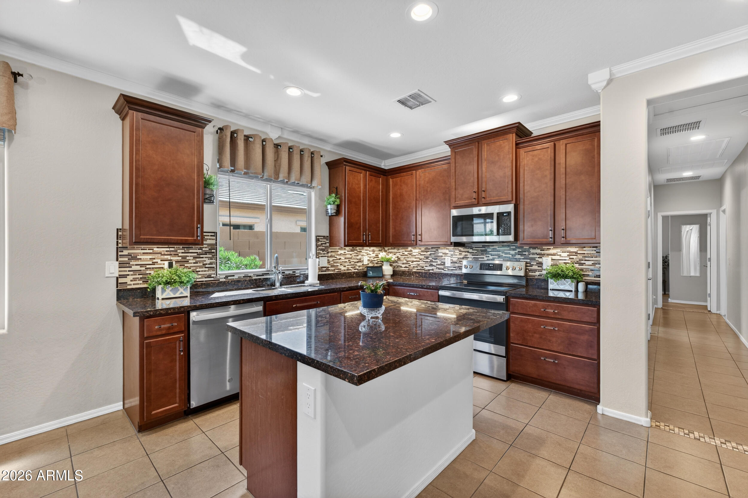 18612 West Mountain View Road Waddell, AZ 85355 - Photo 14 of 71 a kitchen with stainless steel appliances granite countertop a stove a sink and a refrigerator