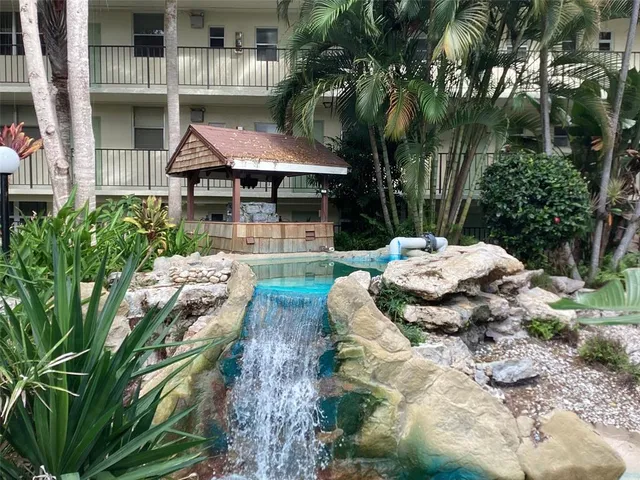 a backyard of a house with table and chairs under an umbrella
