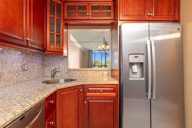 a kitchen with stainless steel appliances granite countertop a refrigerator and a sink