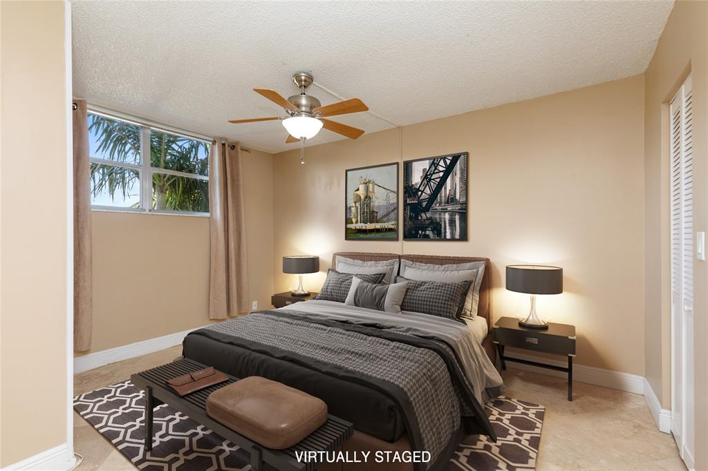 5300 Northeast 24th Terrace, Unit 416C Fort Lauderdale, FL 33308 - Photo 10 of 26 a bedroom with a bed and a chandelier