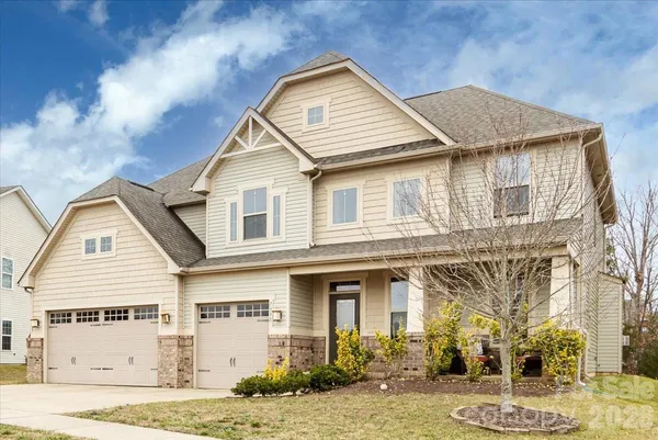 a view of a white house with a yard and large tree