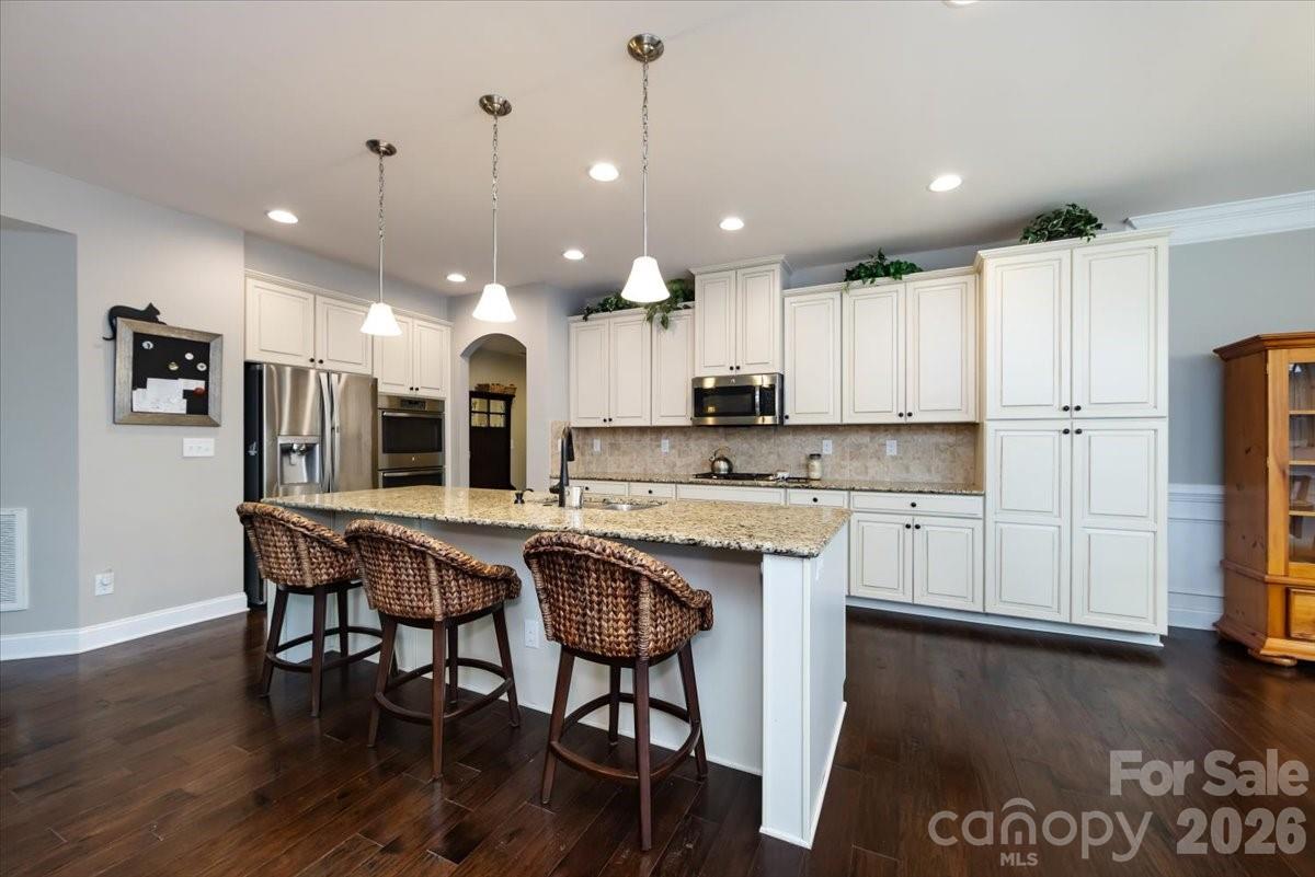 7335 Millstone Circle Southwest Concord, NC 28025 - Photo 12 of 40 a kitchen with stainless steel appliances granite countertop a kitchen island a stove a cabinets a sink and a refrigerator