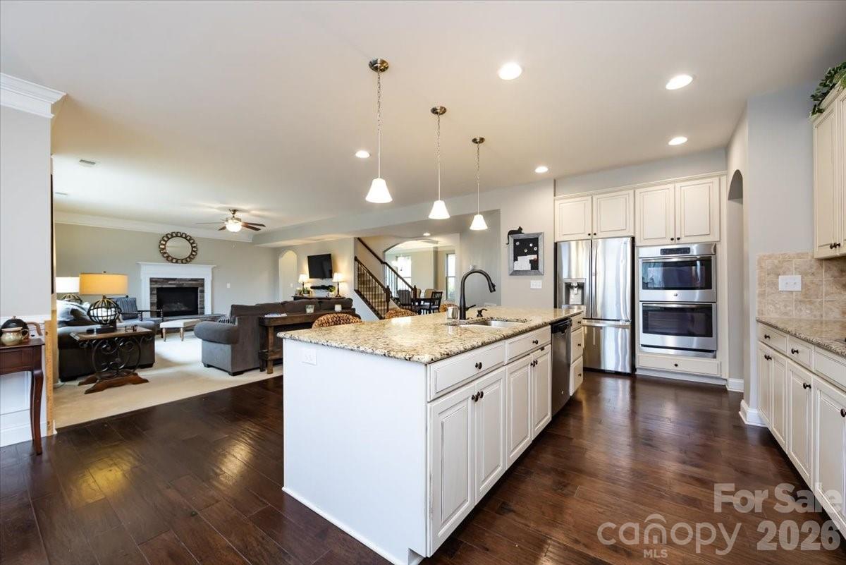 7335 Millstone Circle Southwest Concord, NC 28025 - Photo 15 of 40 a large kitchen with stainless steel appliances kitchen island granite countertop a large counter top and stove