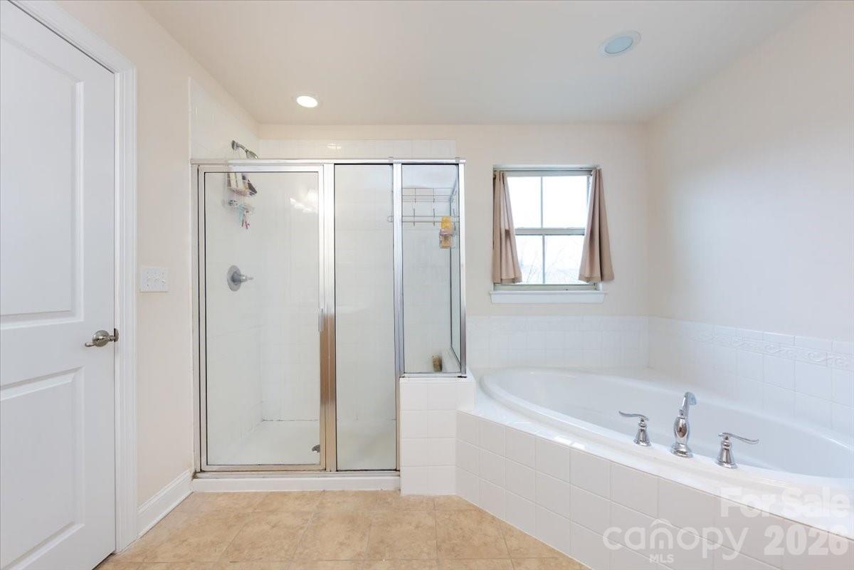 7335 Millstone Circle Southwest Concord, NC 28025 - Photo 26 of 40 a bathroom with a bathtub and a shower