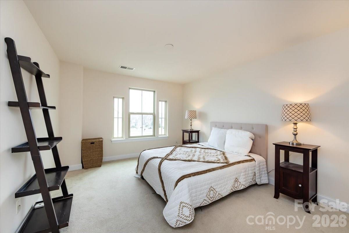 7335 Millstone Circle Southwest Concord, NC 28025 - Photo 31 of 40 a bedroom with a bed a couch and a window