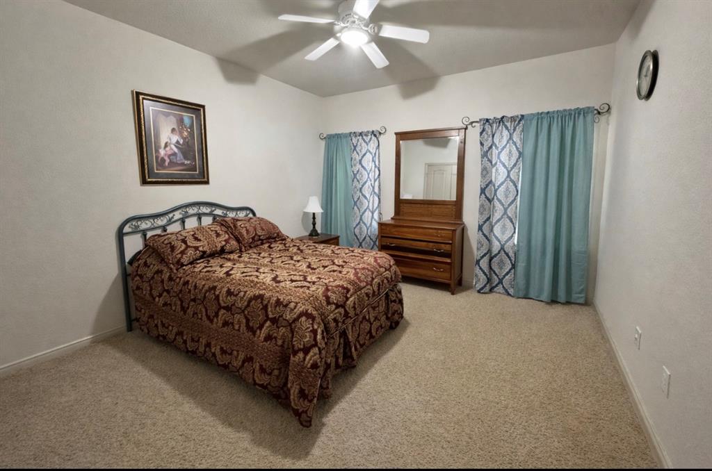 121 Rey Del Mar Circle Weatherford, TX 76085 - Photo 15 of 29 a bedroom with a bed and a chandelier
