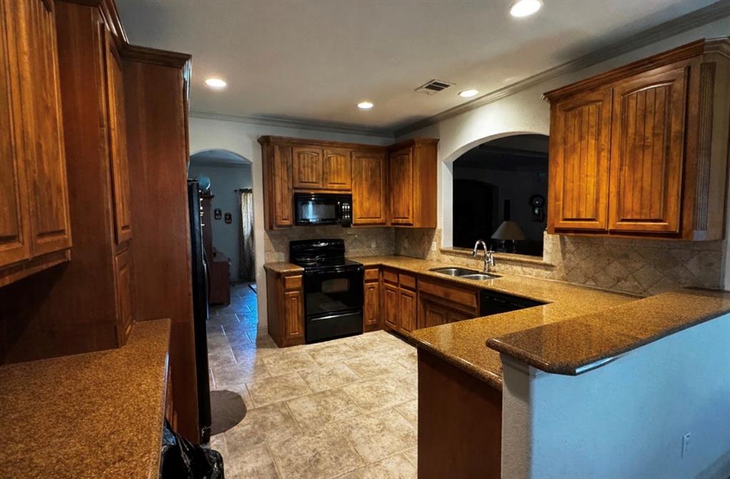 121 Rey Del Mar Circle Weatherford, TX 76085 - Photo 8 of 29 a kitchen with stainless steel appliances granite countertop a sink a stove and a refrigerator