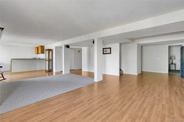 a view of a big room with wooden floor and windows