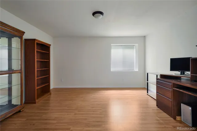 an empty room with wooden floor and closet