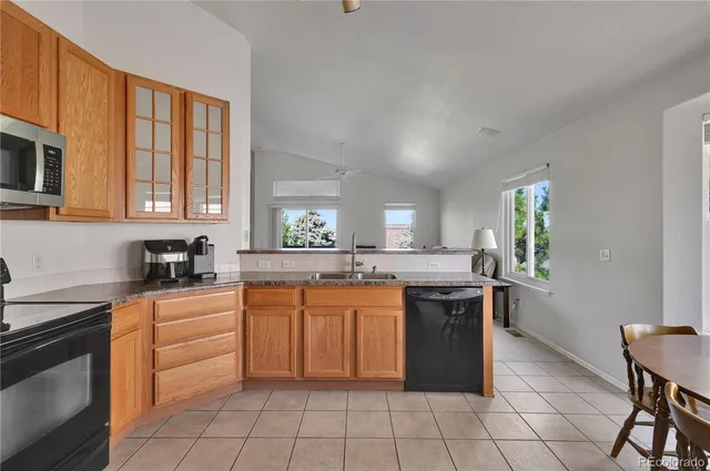 a kitchen with granite countertop a refrigerator and a stove top oven