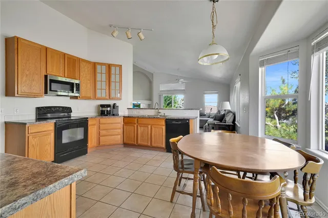 a large kitchen with granite countertop a white table chairs and a wooden floor