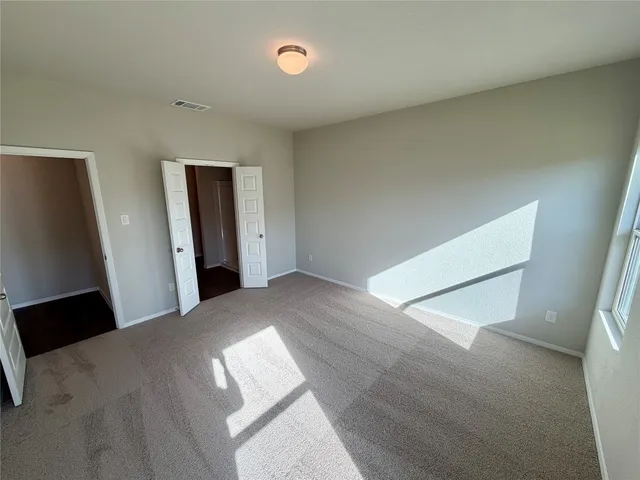a view of a big room with wooden floor and windows