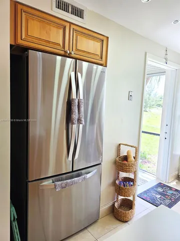a view of a refrigerator in kitchen and a window