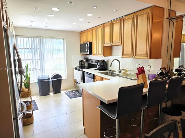 a kitchen with a sink a window and chairs