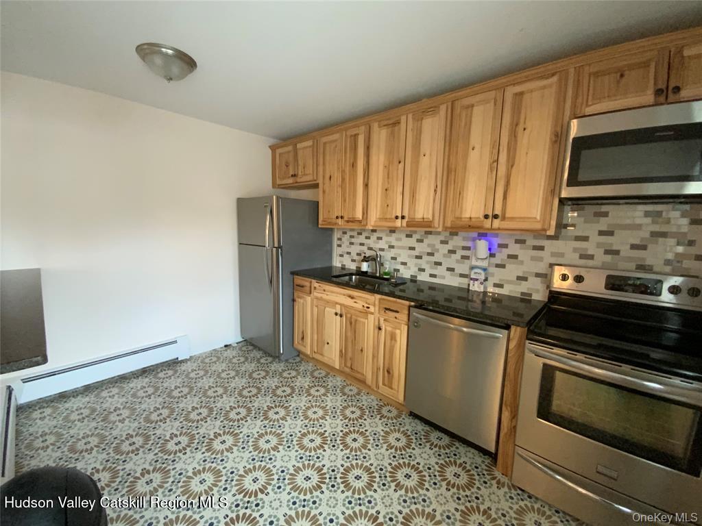 250 Beechwood Avenue Poughkeepsie, NY 12601 - Photo 4 of 7 a kitchen with stainless steel appliances a stove a sink and a microwave