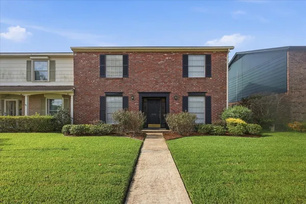 a front view of a brick house with a yard