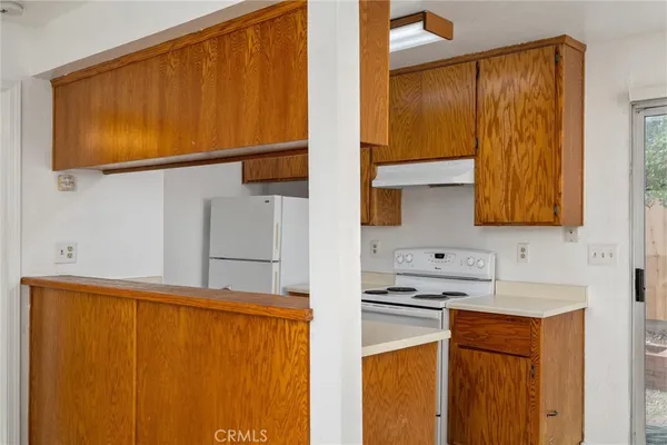 a kitchen with kitchen island granite countertop a refrigerator a stove and a sink with granite countertops