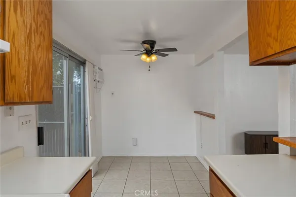 an empty space with a fan & a window