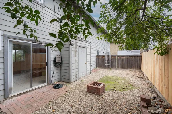 a view of a backyard with wooden fence and large trees