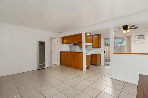 a view of a kitchen with fridge and an empty room