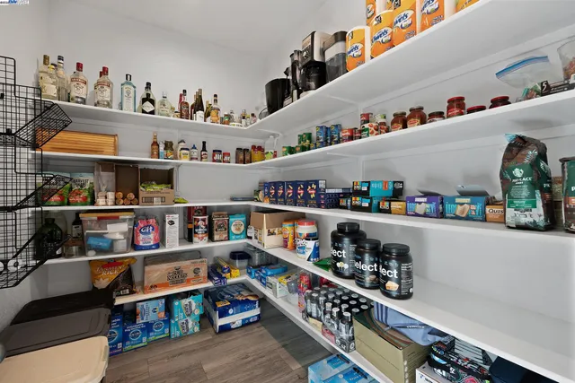 a room with lots of books and a refrigerator