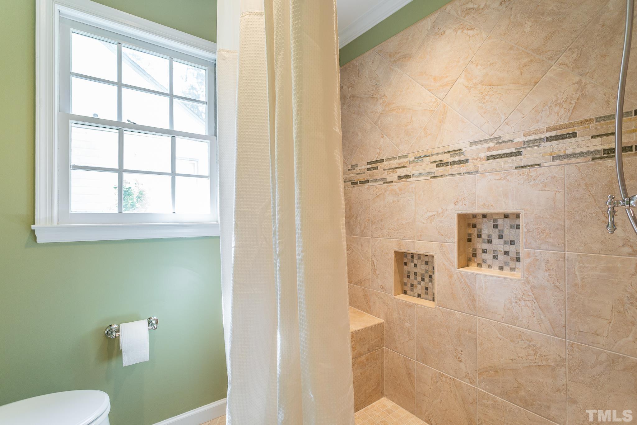 1200 Oakside Court Raleigh, NC 27609 - Photo 15 of 28 a bathroom with a window a toilet and a shower