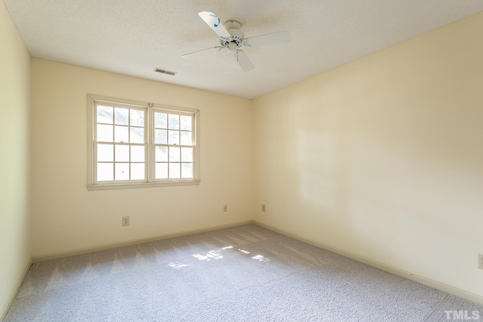 1200 Oakside Court Raleigh, NC 27609 - Photo 18 of 28 an empty room with a window and a ceiling fan