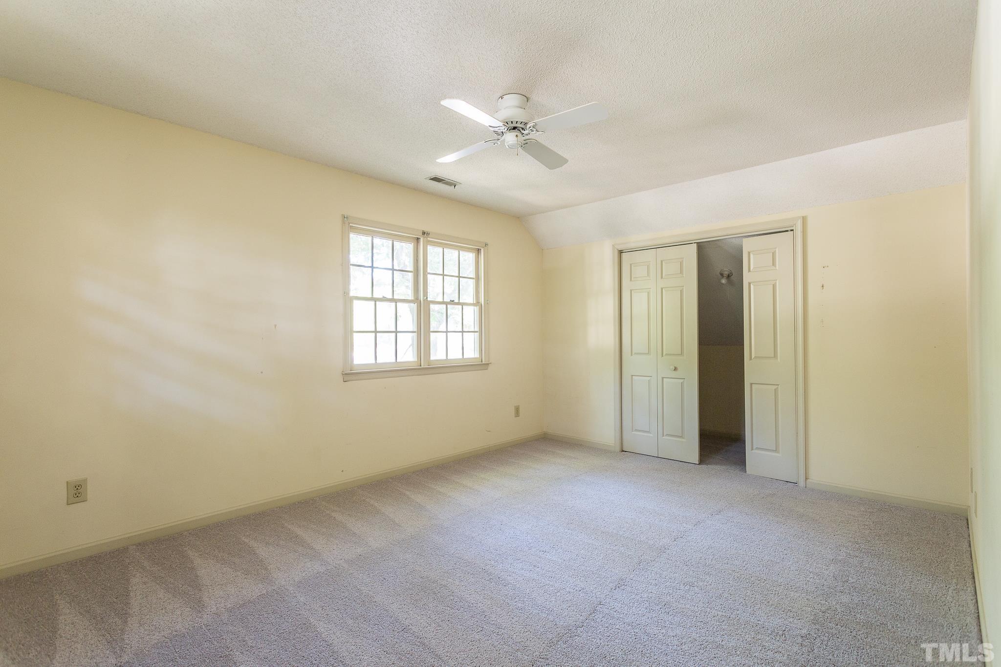 1200 Oakside Court Raleigh, NC 27609 - Photo 19 of 28 an empty room with a ceiling fan and a window