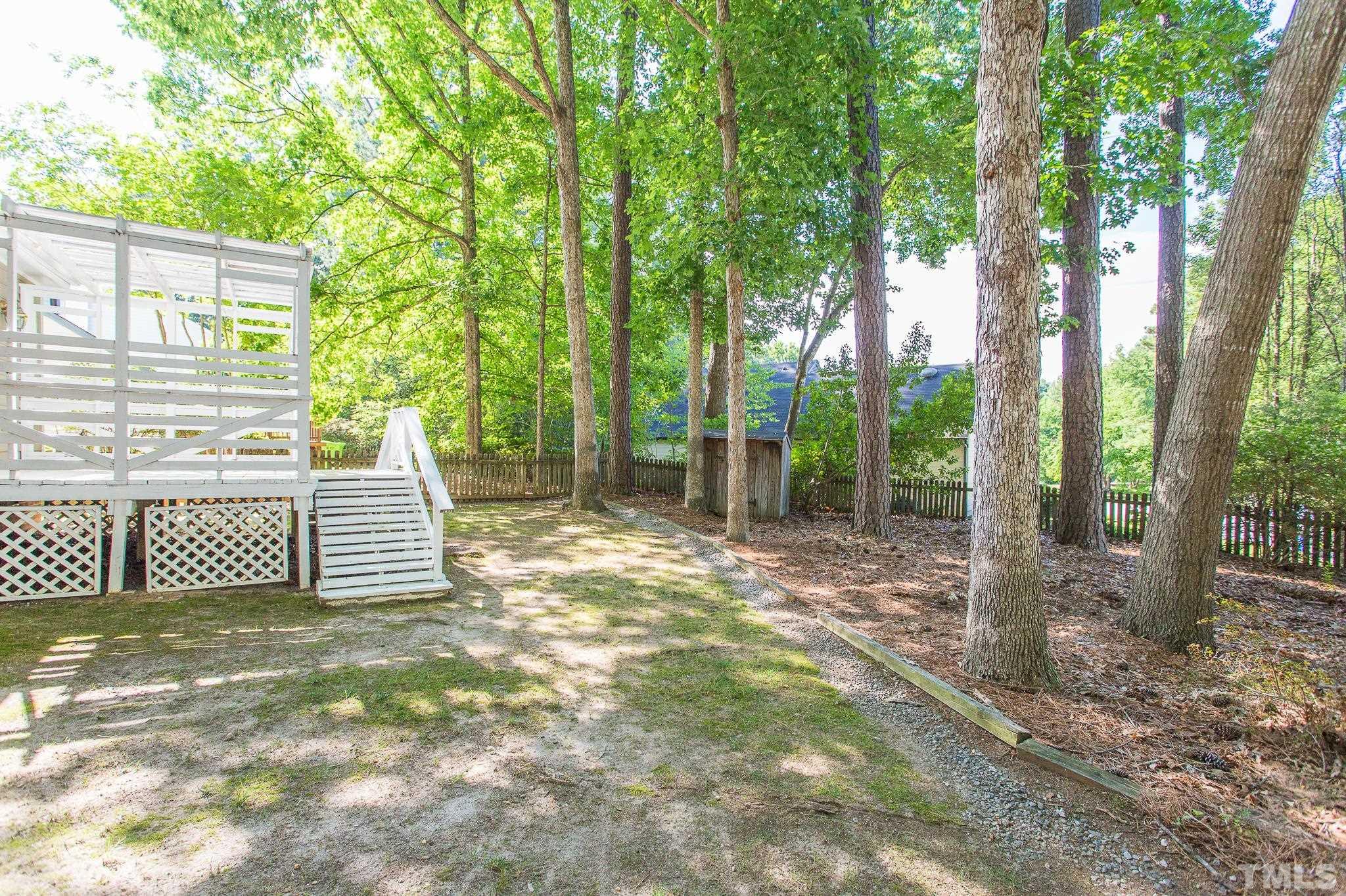 1200 Oakside Court Raleigh, NC 27609 - Photo 27 of 28 a view of a backyard with wooden fence and a large tree
