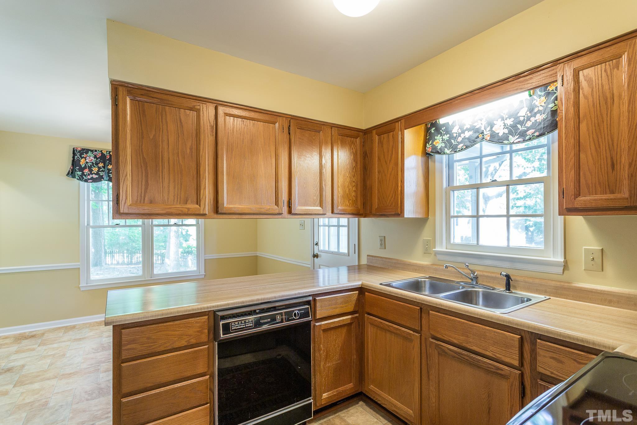 1200 Oakside Court Raleigh, NC 27609 - Photo 6 of 28 a kitchen with a sink cabinets stainless steel appliances and a large window