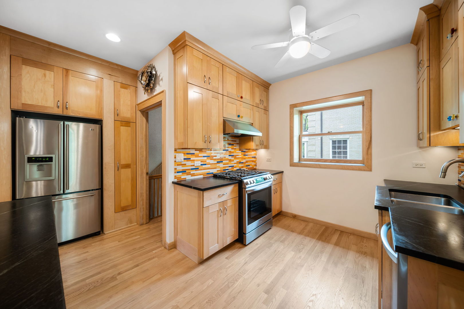 380 Fairbank Road Riverside, IL 60546 - Photo 12 of 30 a kitchen with stainless steel appliances granite countertop a refrigerator a stove and a sink with wooden floor