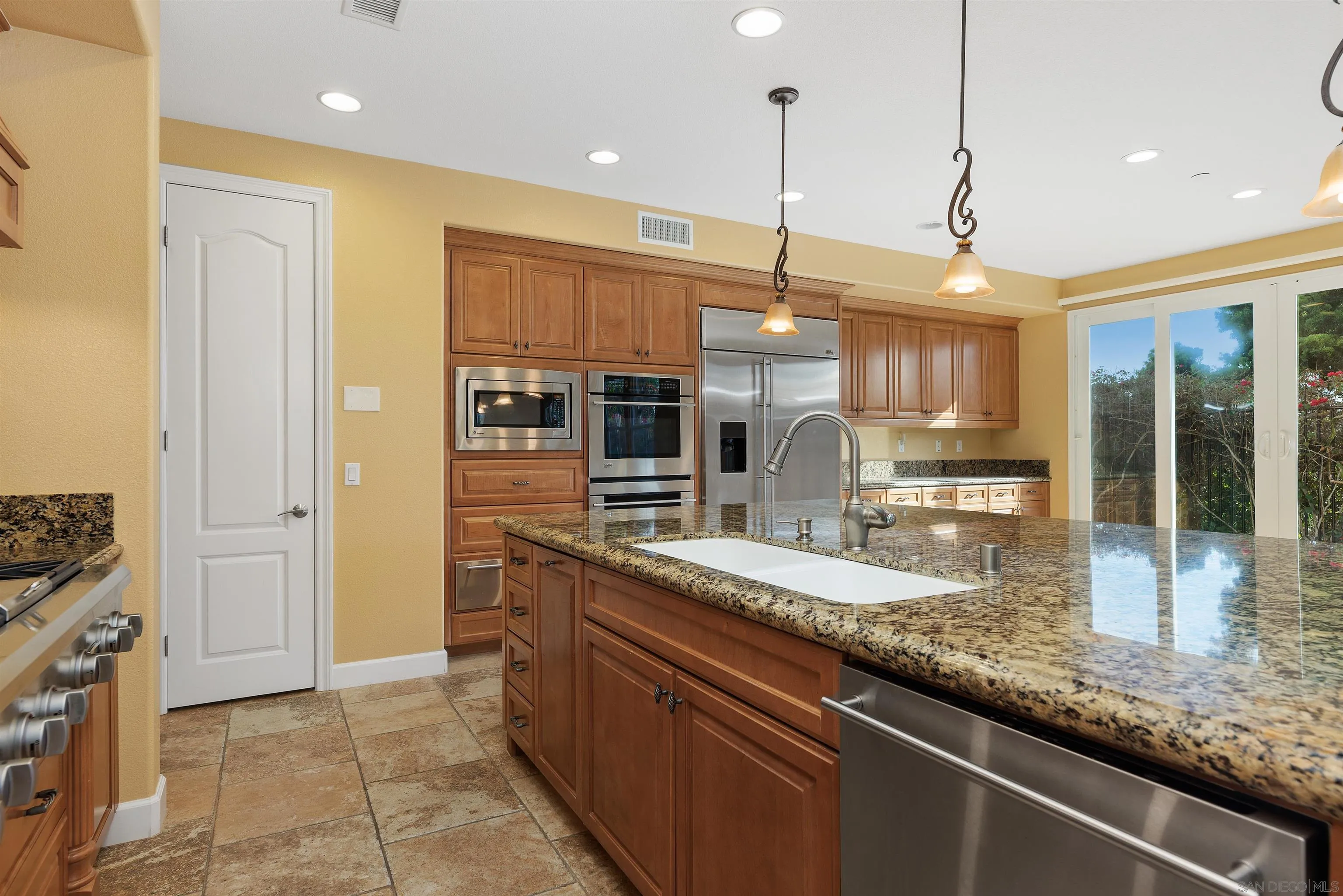 527 Quail Pointe Lane Encinitas, CA 92024 - Photo 17 of 46 a kitchen with stainless steel appliances granite countertop a sink a stove and a refrigerator