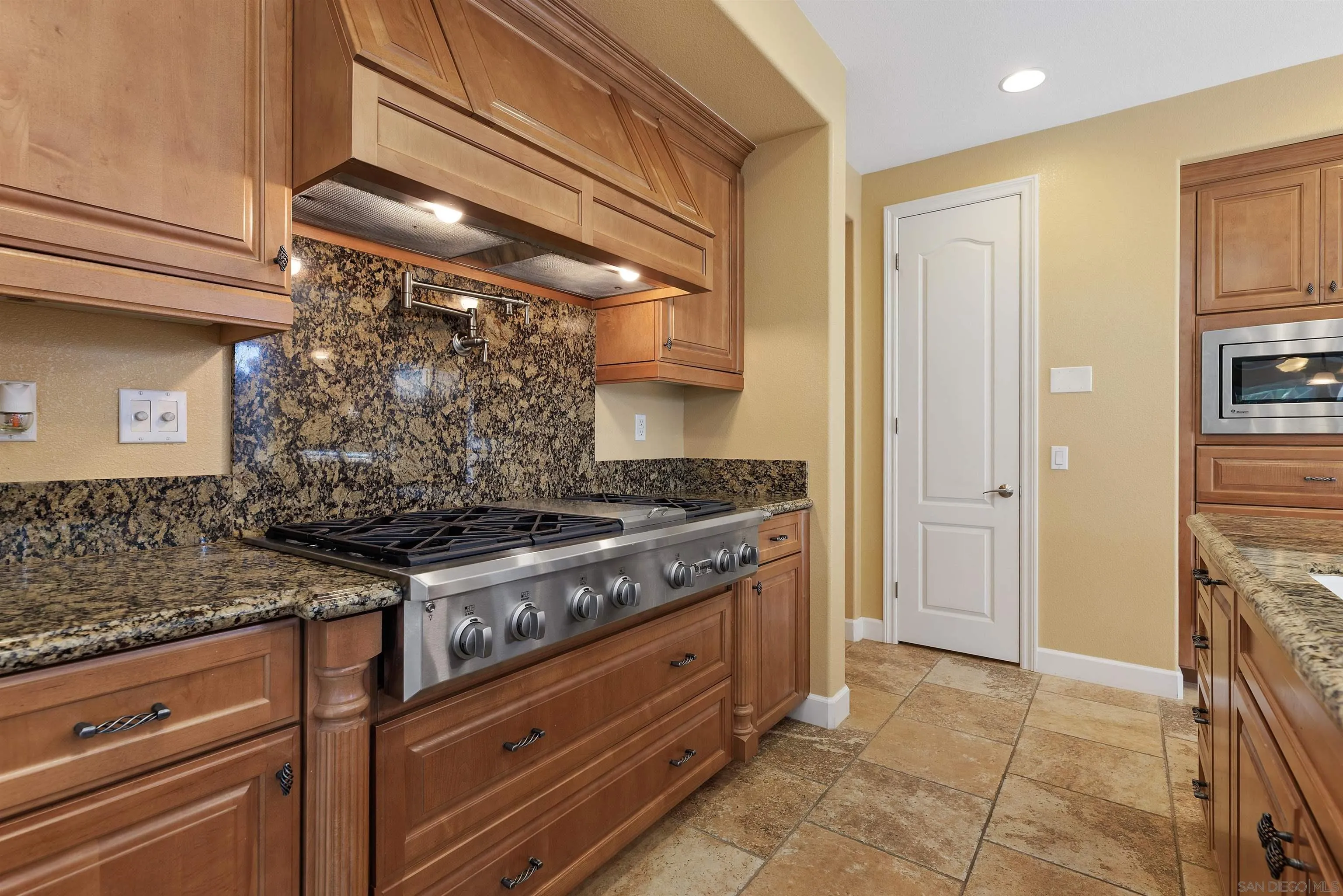 527 Quail Pointe Lane Encinitas, CA 92024 - Photo 18 of 46 a kitchen with stainless steel appliances granite countertop a stove and a refrigerator