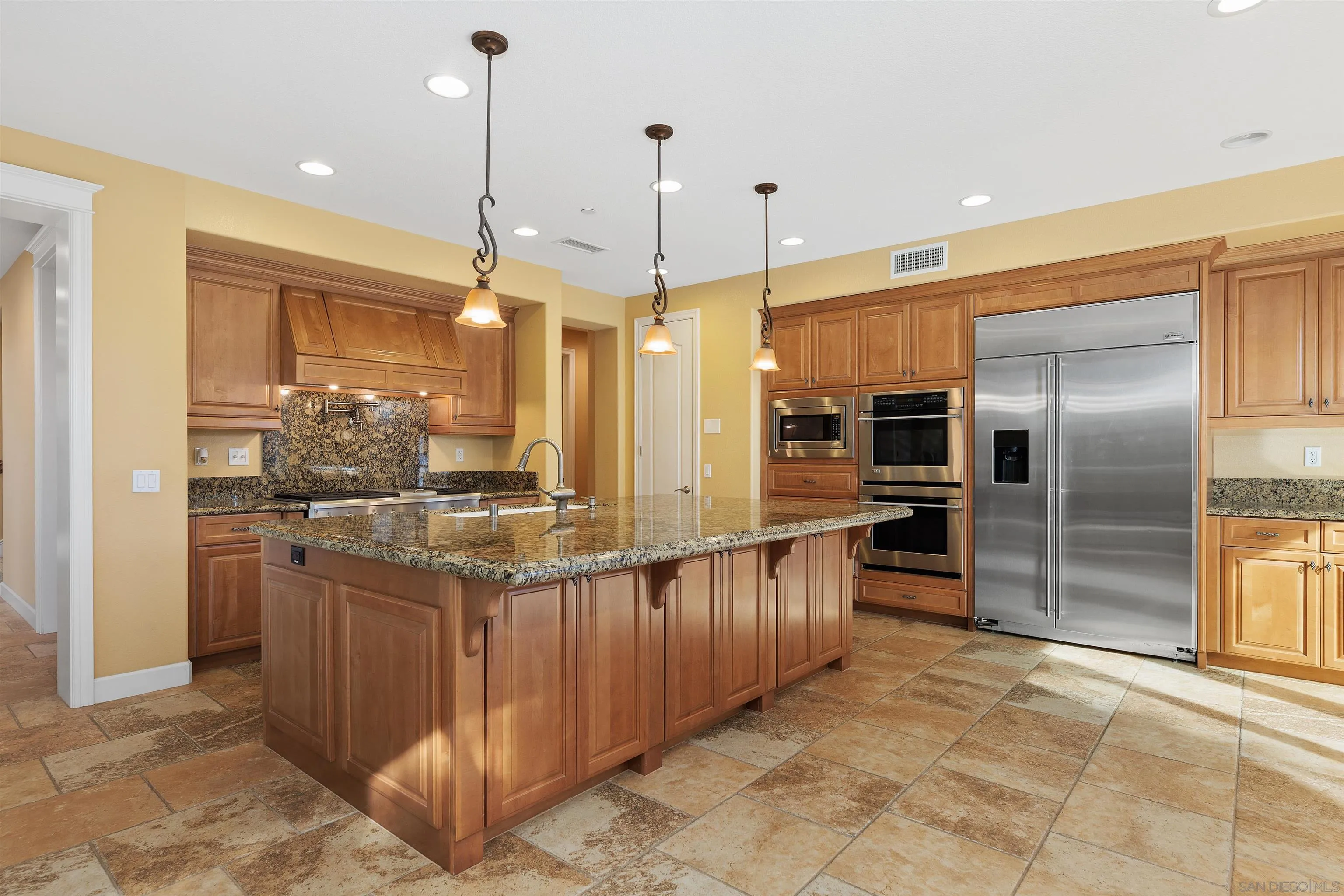 527 Quail Pointe Lane Encinitas, CA 92024 - Photo 19 of 46 a kitchen with stainless steel appliances kitchen island granite countertop a refrigerator and a sink