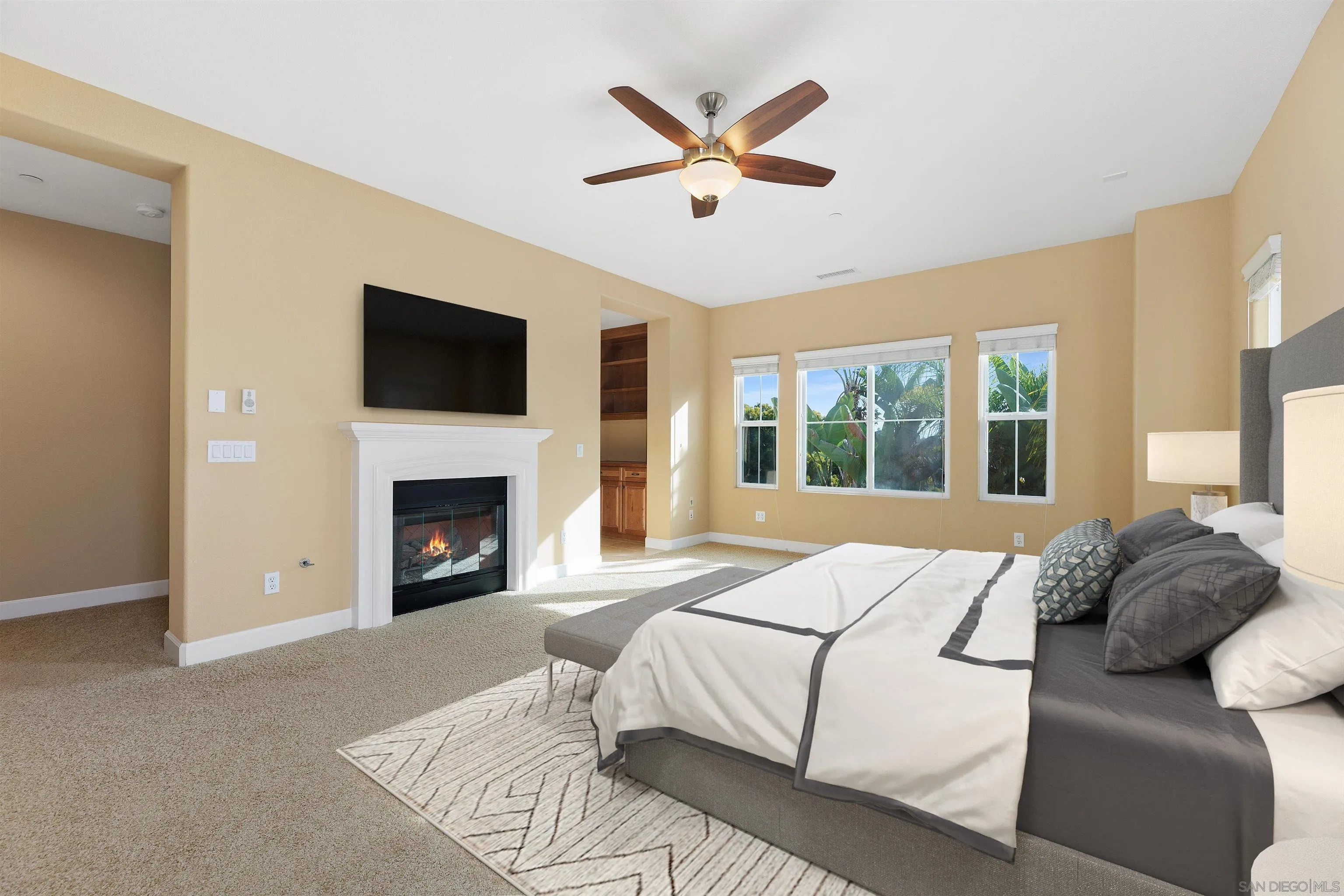 527 Quail Pointe Lane Encinitas, CA 92024 - Photo 26 of 46 a bedroom with a large bed and a fireplace