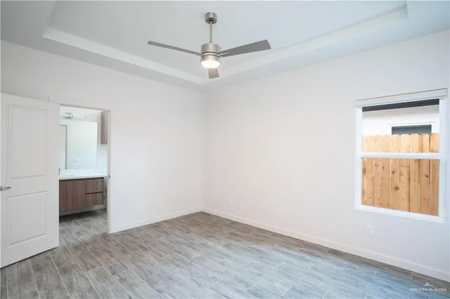 an empty room with a window and a ceiling fan