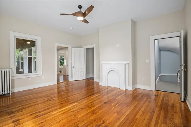a view of a livingroom with wooden floor and a ceiling fan