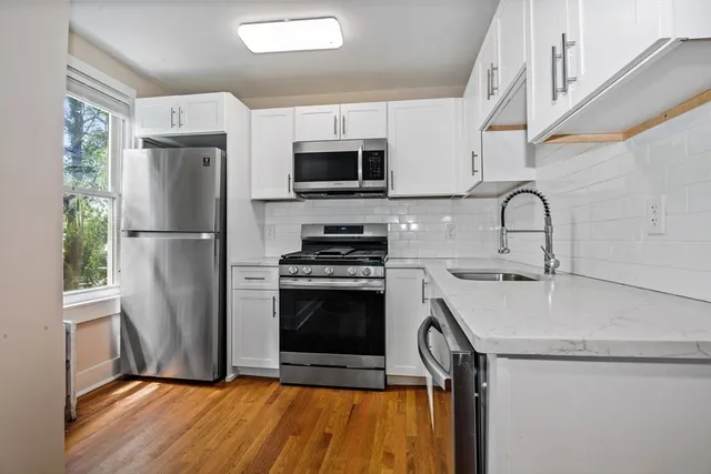 a kitchen with stainless steel appliances a refrigerator sink and microwave