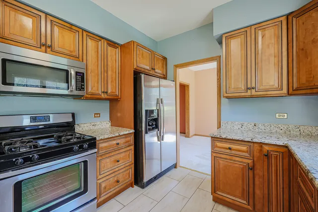 a kitchen with stainless steel appliances granite countertop a stove microwave and refrigerator