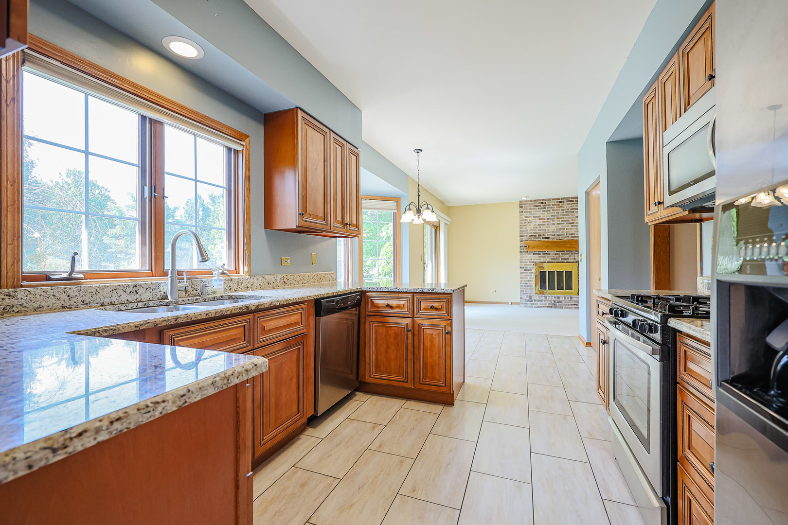 629 Dogleg Lane Bartlett, IL 60103 - Photo 13 of 37 a large kitchen with stainless steel appliances granite countertop a stove a sink and a microwave