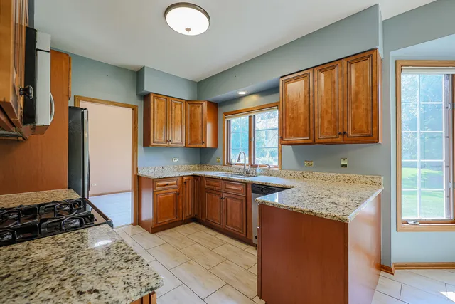 a kitchen with stainless steel appliances granite countertop a stove a sink dishwasher and a refrigerator