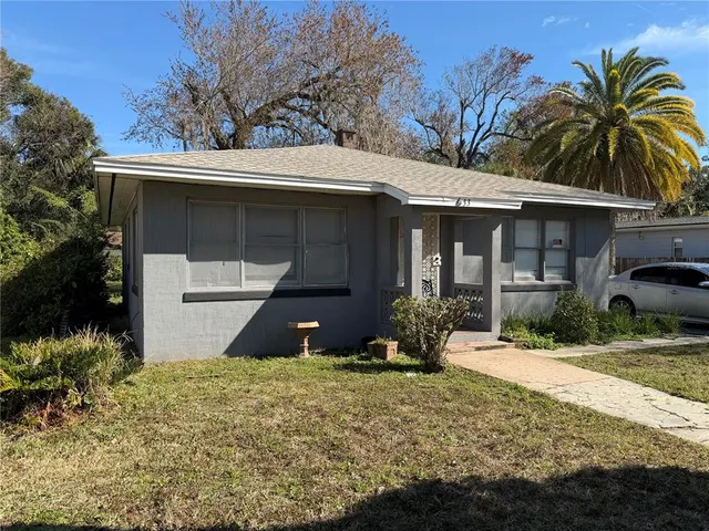 a front view of house with yard and trees around