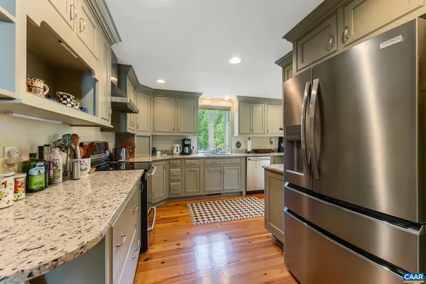 a kitchen with stainless steel appliances granite countertop a refrigerator a sink and a stove