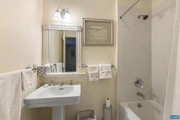 a bathroom with a sink tub shower and a mirror