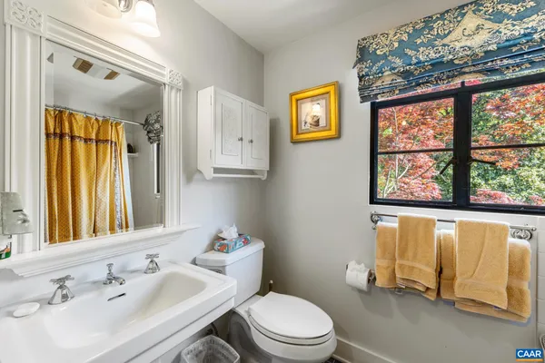 a bathroom with a sink a toilet and a large mirror