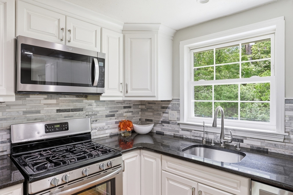 33 Simon Willard Road Acton, MA 01720 - Photo 9 of 42 a kitchen with granite countertop a stove a sink and a microwave