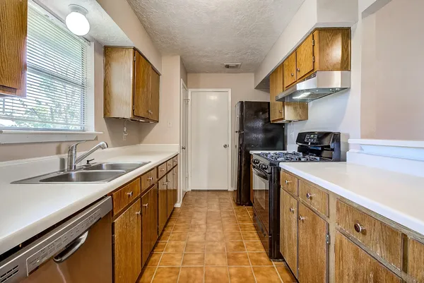 a kitchen with stainless steel appliances granite countertop a sink and dishwasher a stove top oven with wooden floor