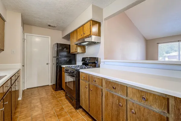 a kitchen with stainless steel appliances granite countertop a refrigerator and a stove top oven